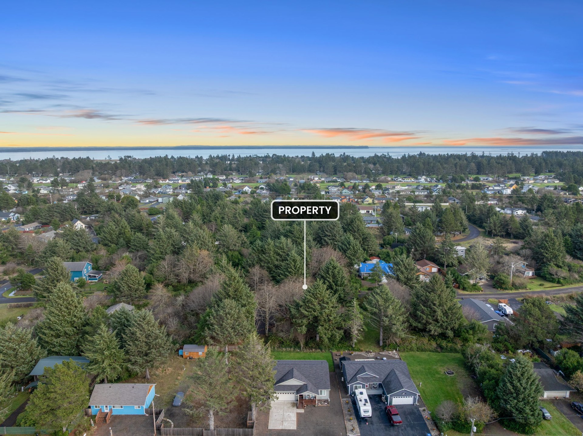 Aerial showing the surrounding neighborhood and coastline at 337 Mast Ave NW